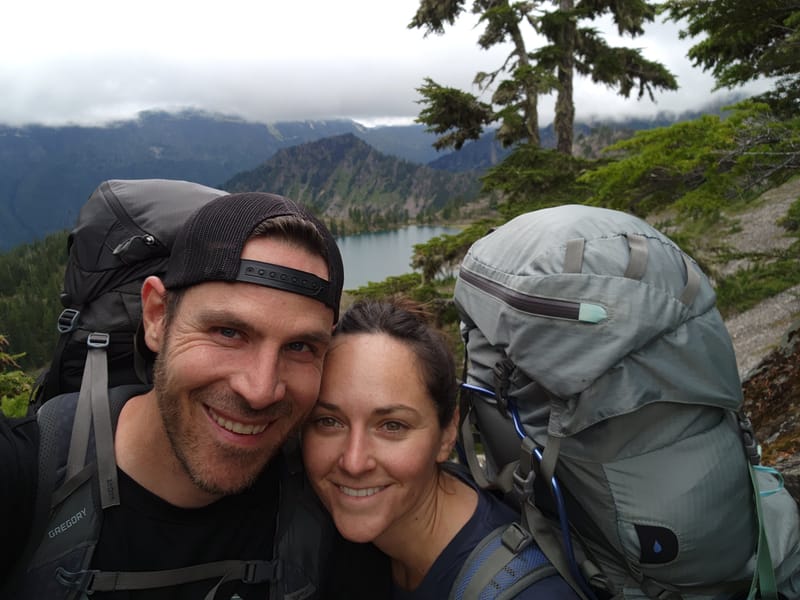 Jared and his fiancée backpacking above an alpine lake on the Olympic Peninsula